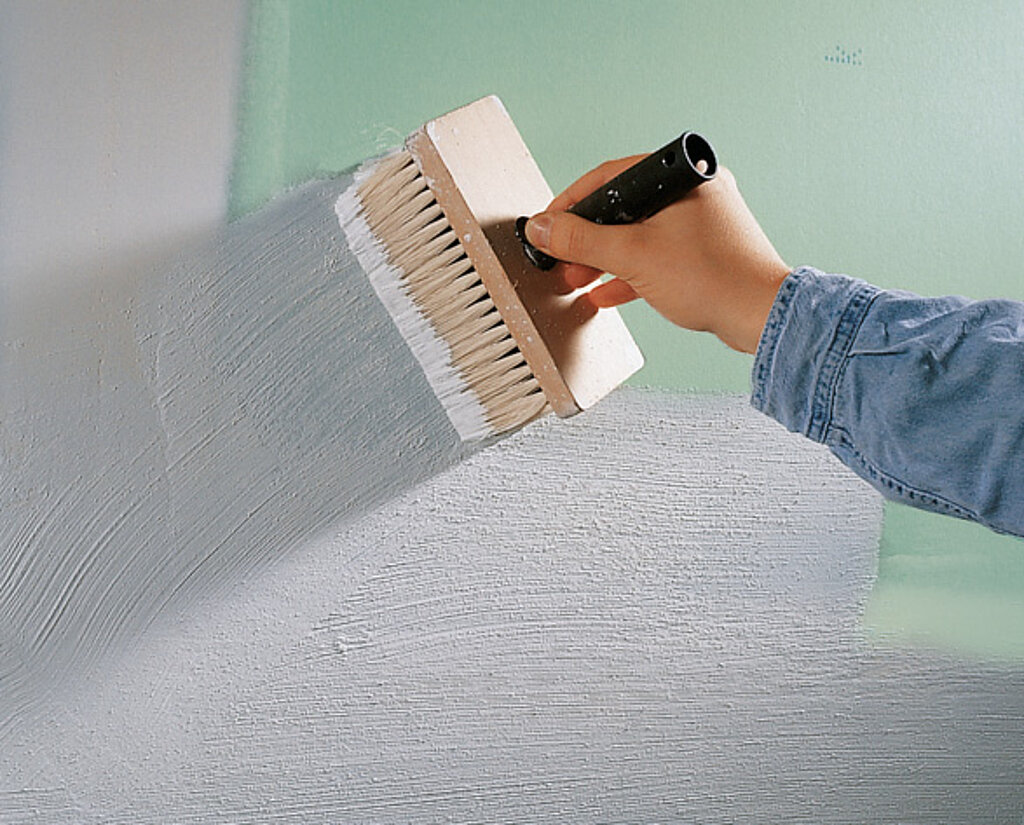 Fliesen an die Wand kleben, Gipskartonplatte wird mit einem Quast grundiert um die Saugfähigkeit zu minimieren
