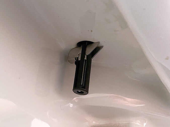 Klodeckel wechseln & pflegen – Montage des neuen Toilettensitz-Nahaufnahme des Spezialdübels mit Metall-Kipp-Funktion von unten