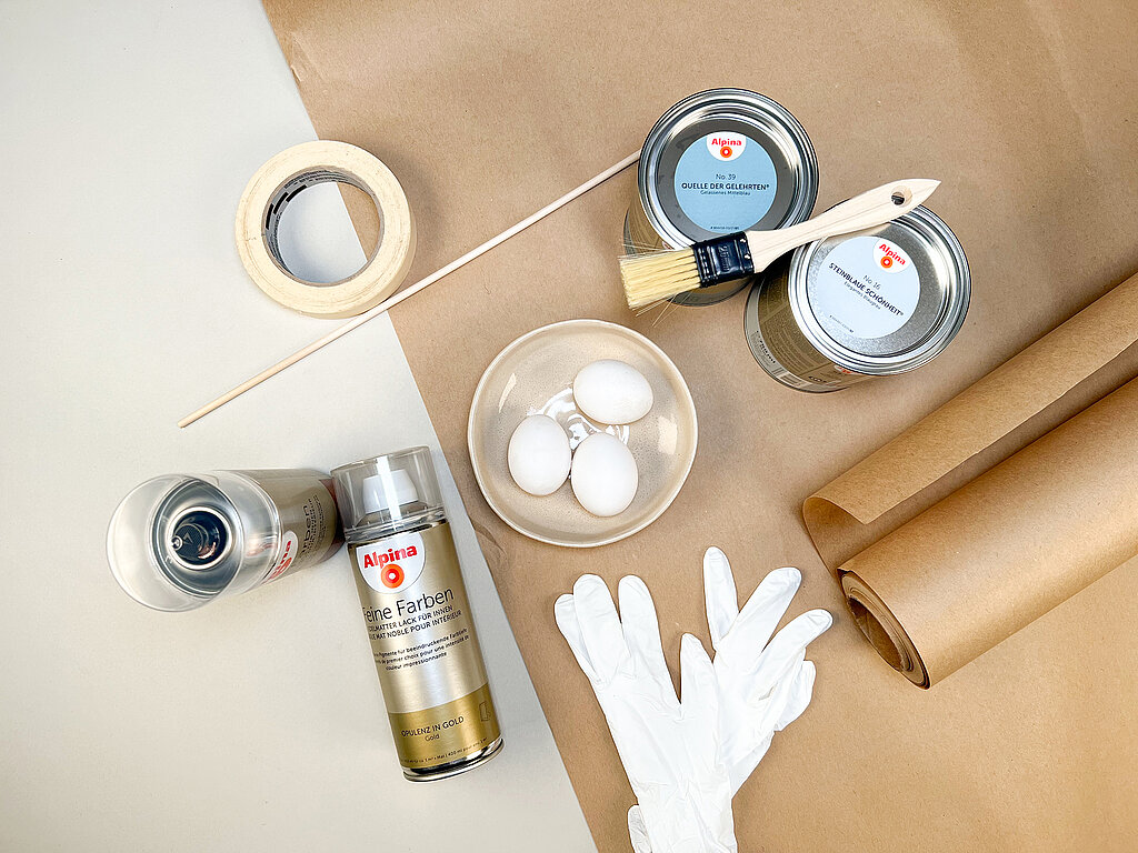 0stereier färben mit Sprühlack und Schablonen: Materialien wie weiße Eier, Kreppband, Handschablone und Farbdosen für kreative DIY Osterprojekte vorbereitet
