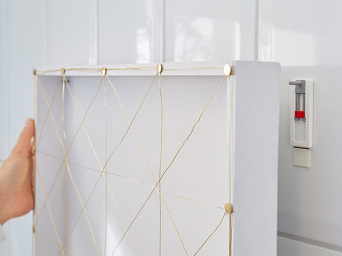 Wanddeko mit Pflanzen fertig montiert, bespannter Rahmen mit Garnstruktur als moderne DIY-Wanddekoration