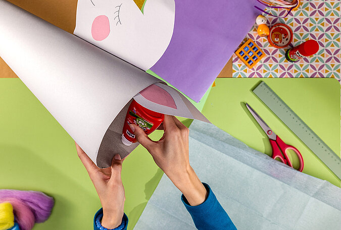 Schultüte Einhorn basteln mit Kleber und Krepppapier zum Verschließen der Schultüte