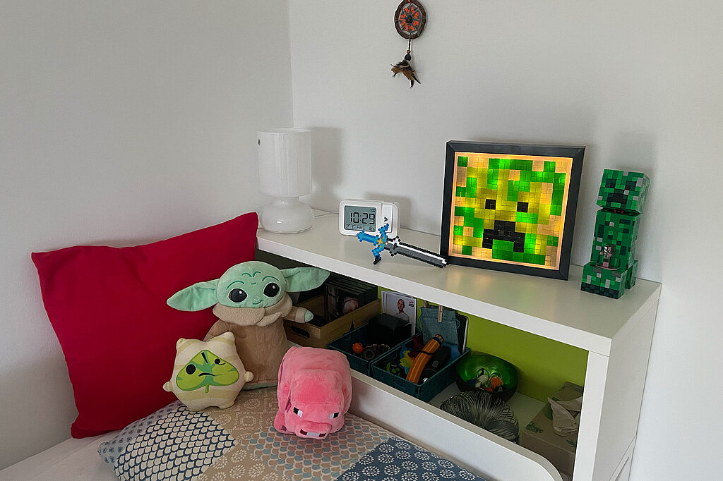 Creeper-Deko-Leuchte basteln als leuchtende Deko im Kinderzimmer auf Regal mit Minecraft-Figuren und Gaming-Accessoires