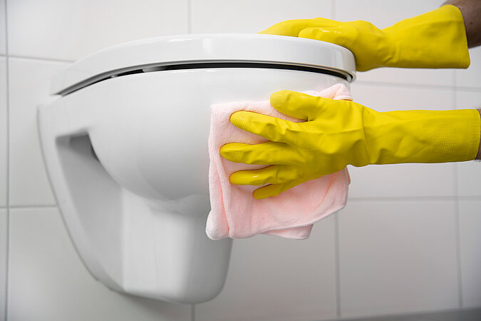 Klodeckel wechseln & pflegen – Toilette wird mit Gummihandschuhen und Mikrofasertuch gründlich gereinigt