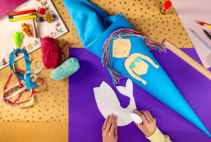 Schultüte Meerjungfrau basteln mit aufgeklebter Glitzerflosse und Meerjungfrauenmotiv auf der Schultüte