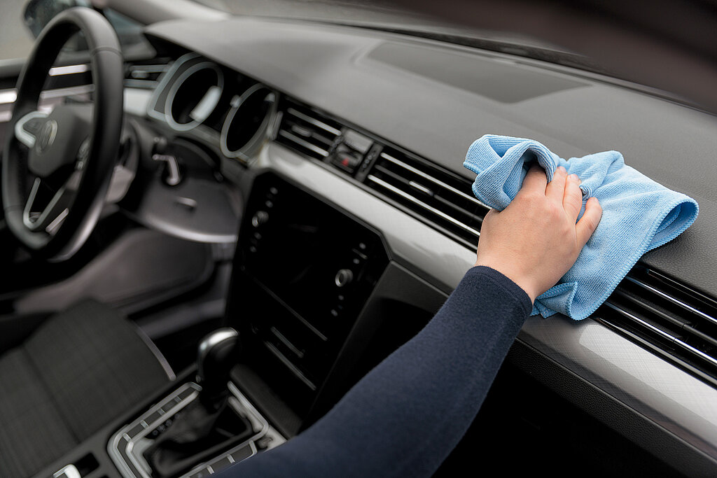 Auto selbst waschen Cockpitpflege – Hand säubert Cockpit und Kunsstoffoberflächen mit Mikrofasertuch