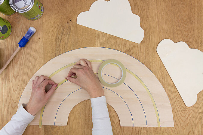 Wandleuchte im Regenbogen-Design bauen – Die Form des Regenbogens wird mit Kreppband abgeklebt, um jeden Bogen farblich zu gestalten.