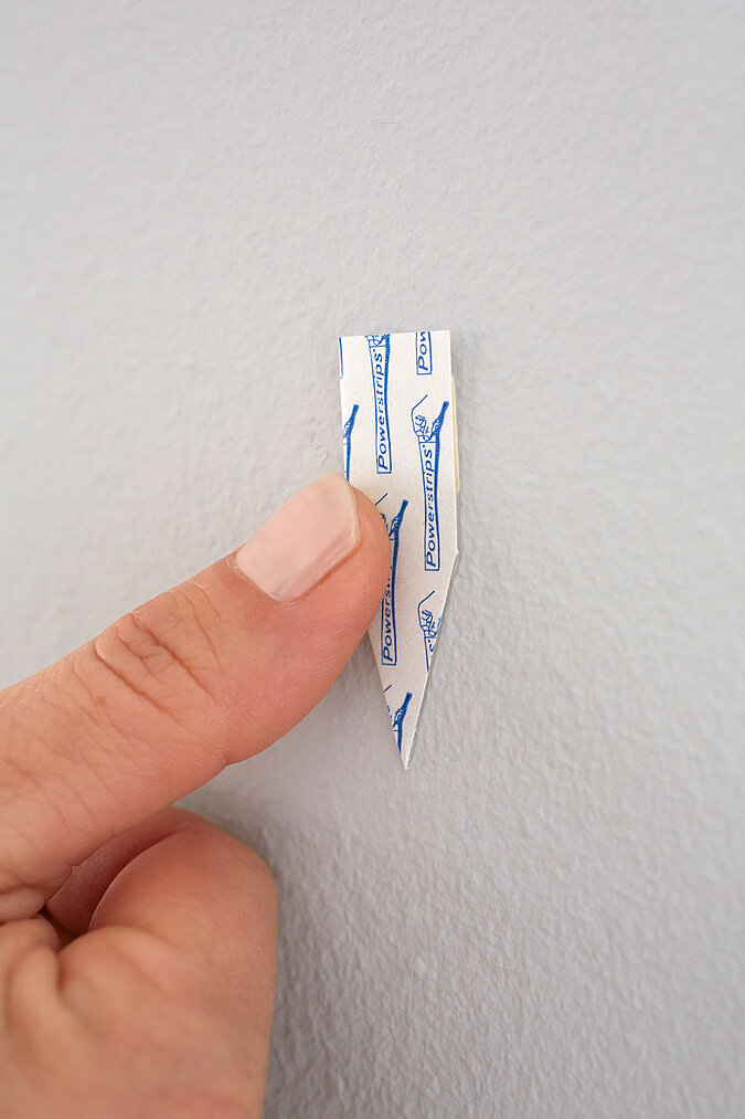 Klebehaken wird an die Wand geklebt