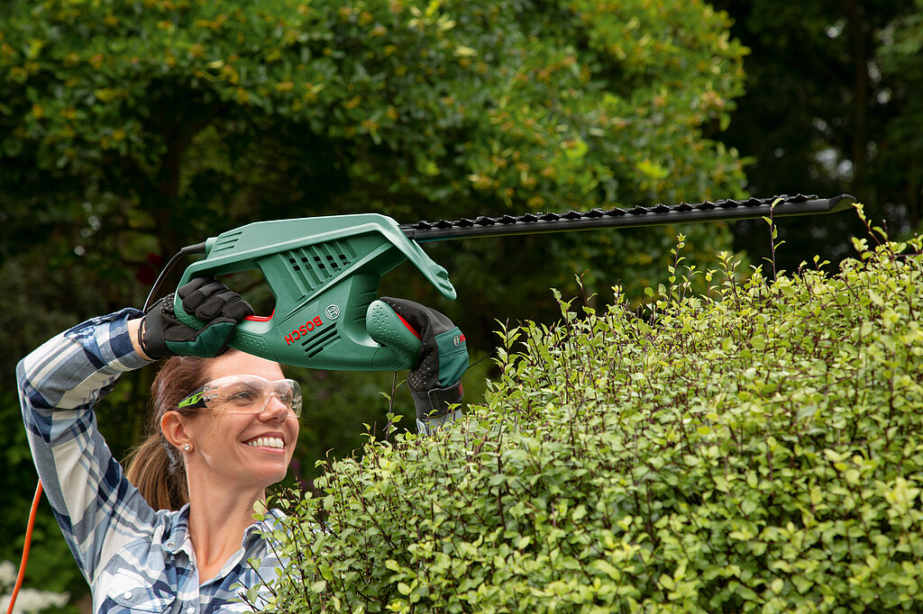 Frau mit Heckenschere mit Kabel